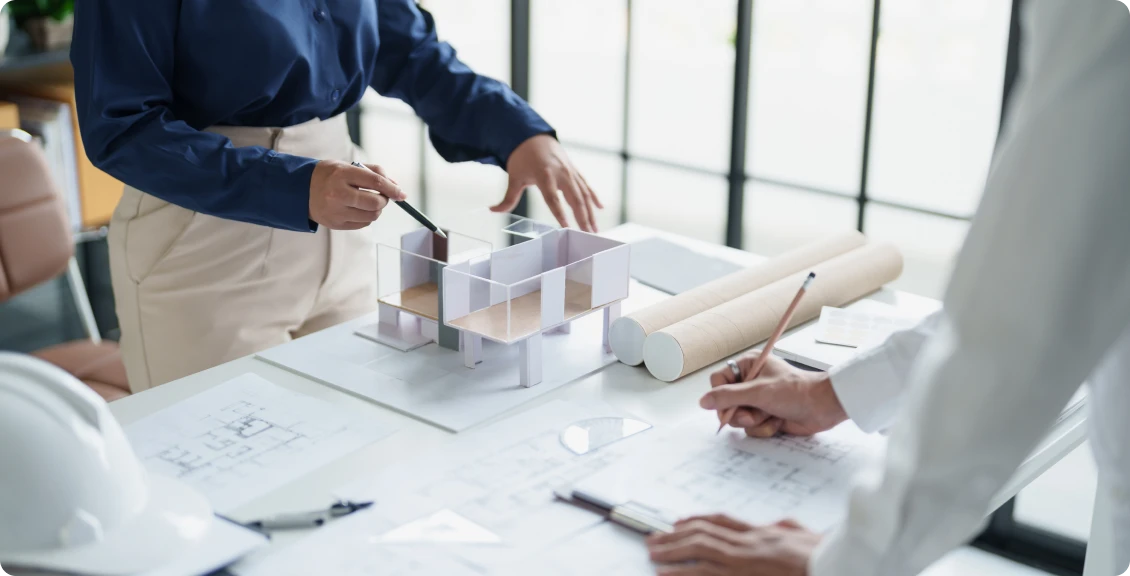 Hands pointing at architectural scale model